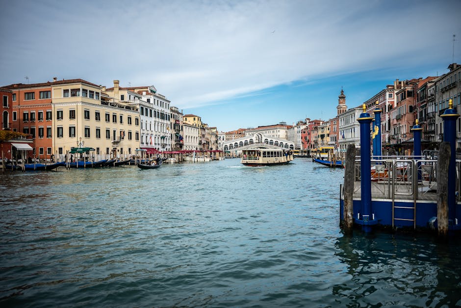 Scenic shot of Grand Canal, Venice showcasing iconic architecture and gondolas on a sunny day.