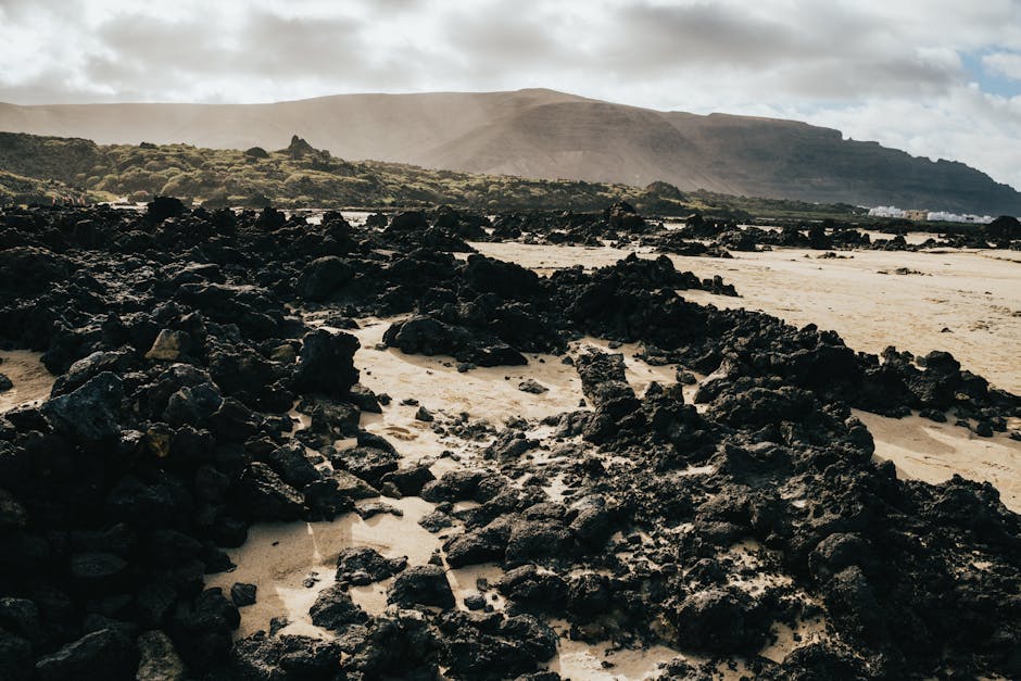 Rugged volcanic terrain at Lanzarote, showcasing dramatic natural scenery under cloudy skies.