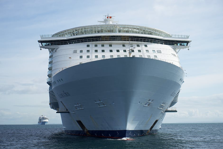 Front view of a luxury cruise ship navigating the sea under a clear sky.